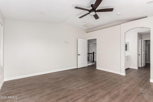 unfurnished bedroom featuring ceiling fan, lofted ceiling, dark wood-type flooring, and ensuite bath