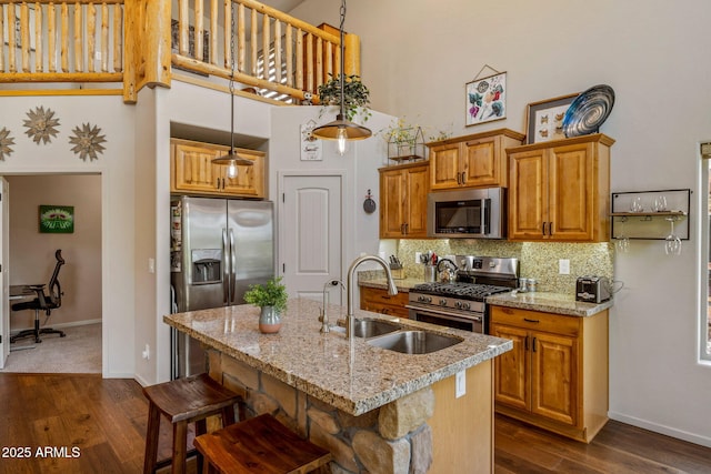 2540 W Waters Edge Ln, Lakeside, AZ 85929 - kitchen with stainless steel appliances, a towering ceiling, dark wood-style floors, light stone countertops, and a center island with sink