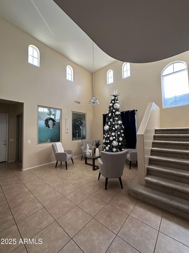 living area with light tile patterned flooring and a towering ceiling