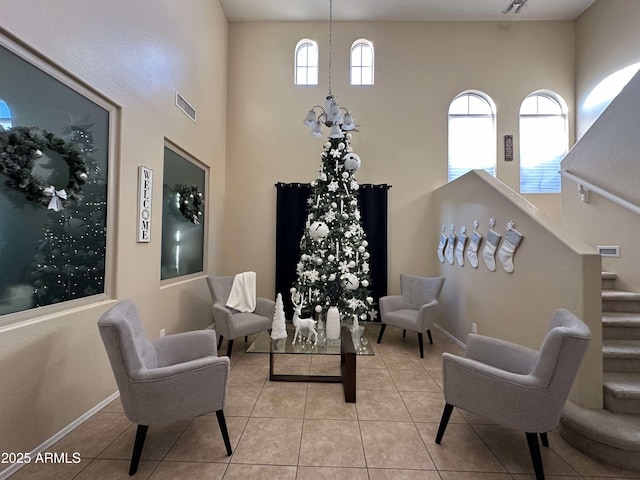 living area featuring light tile patterned flooring, a healthy amount of sunlight, and a chandelier