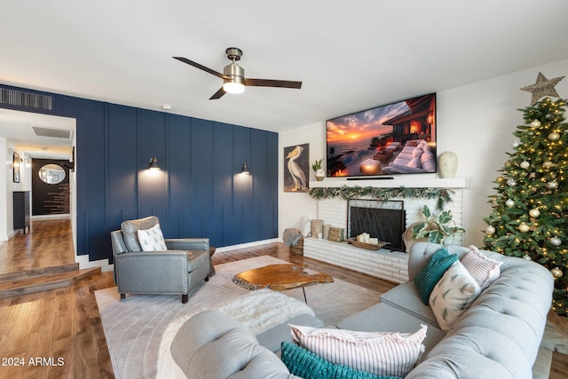 living room with a fireplace, hardwood / wood-style floors, and ceiling fan