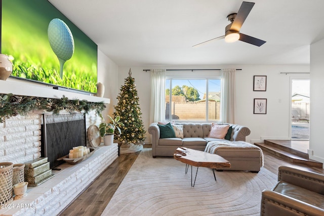 living room featuring a fireplace, hardwood / wood-style flooring, and ceiling fan