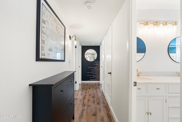 corridor with dark hardwood / wood-style flooring and sink