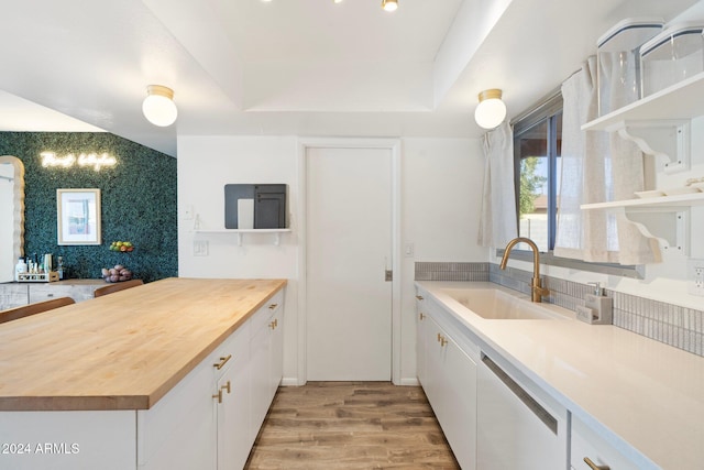 kitchen featuring dishwasher, sink, light wood-type flooring, white cabinetry, and butcher block counters