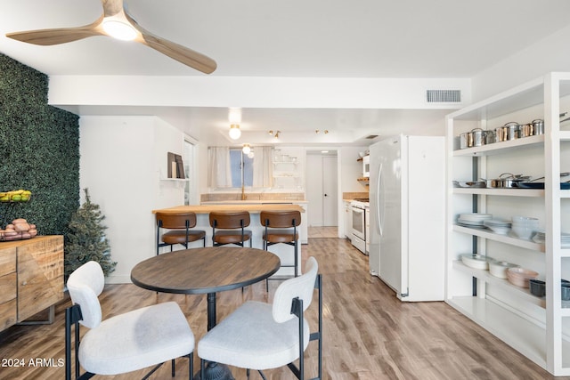 dining area with ceiling fan and light hardwood / wood-style flooring