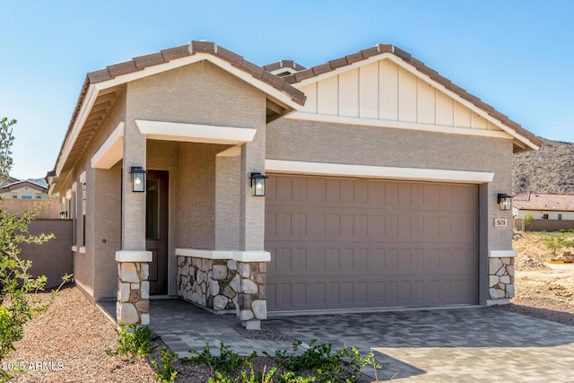 5664 N 205th Ln, Buckeye, AZ 85396 - view of front of house featuring a garage, decorative driveway, stone siding, and stucco siding