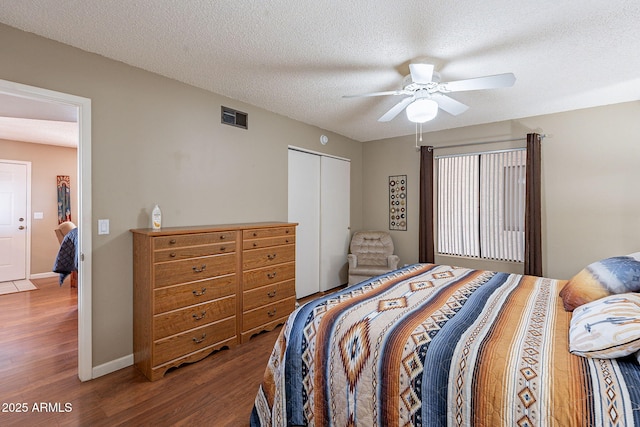 bedroom featuring wood-type flooring, ceiling fan, a textured ceiling, and a closet