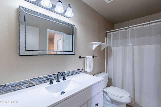 bathroom with tasteful backsplash, vanity, and toilet