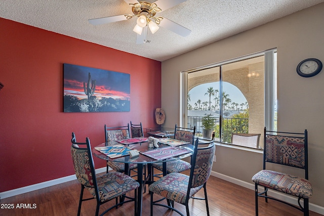 dining area with hardwood / wood-style flooring, ceiling fan, and a textured ceiling