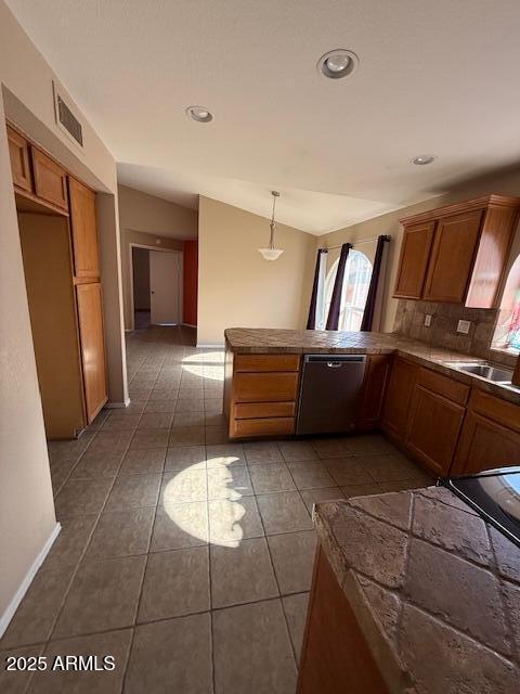 kitchen featuring pendant lighting, dark tile patterned floors, dishwasher, backsplash, and vaulted ceiling