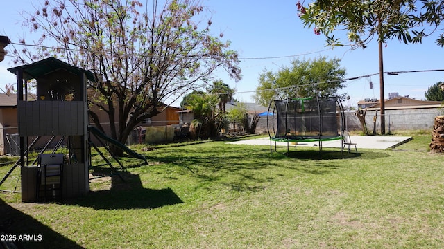 view of yard featuring a playground, a trampoline, and a fenced backyard