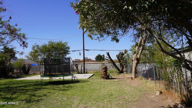 view of yard with a trampoline and a fenced backyard