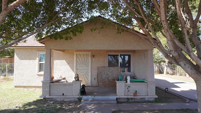 view of front facade featuring fence and stucco siding