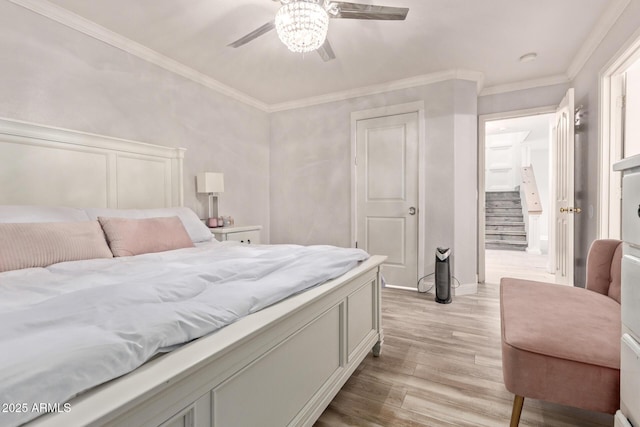 bedroom featuring light wood-style floors, ceiling fan, and ornamental molding