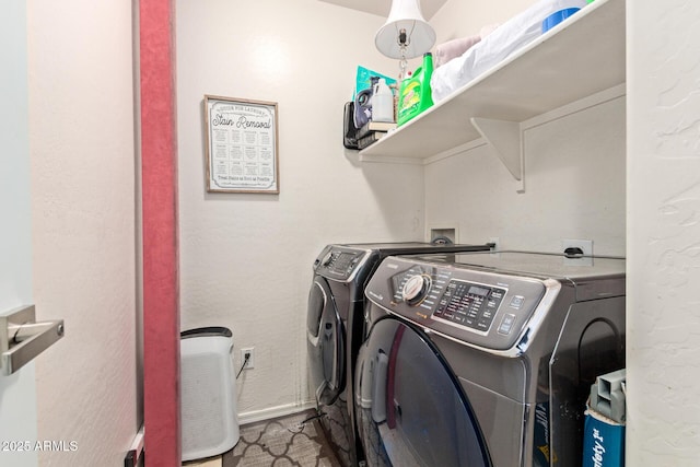 washroom with laundry area, baseboards, and washing machine and clothes dryer