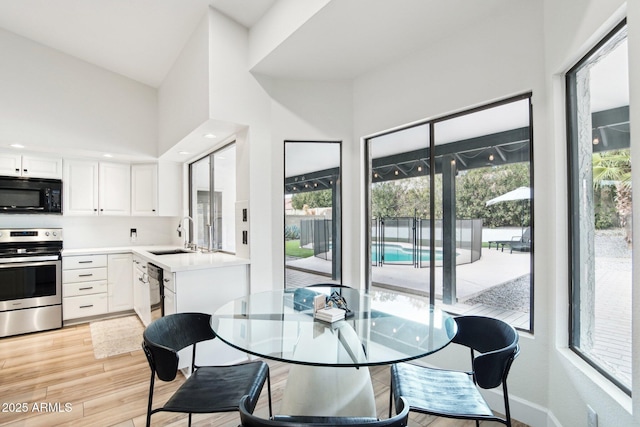 dining area featuring light wood-type flooring and baseboards