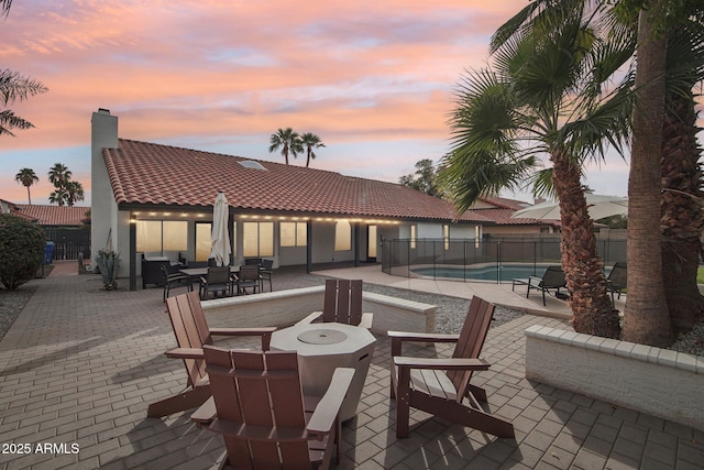 exterior space with a fire pit, a patio, fence, and a fenced in pool