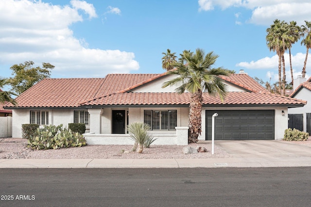 view of front of home featuring an attached garage, a tile roof, and stucco siding