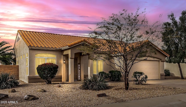 mediterranean / spanish house with stucco siding, concrete driveway, and a tile roof