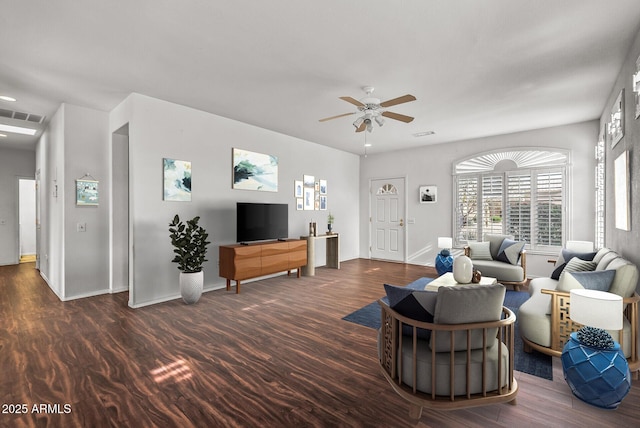 living room with visible vents, baseboards, dark wood-type flooring, and ceiling fan