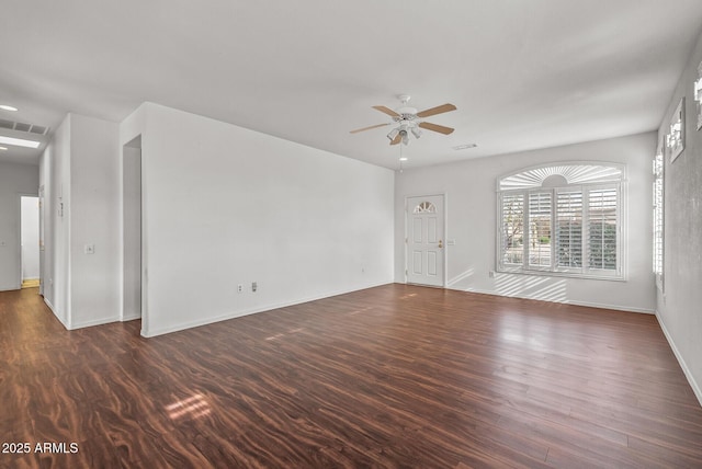 unfurnished living room with a ceiling fan, visible vents, dark wood-style flooring, and baseboards