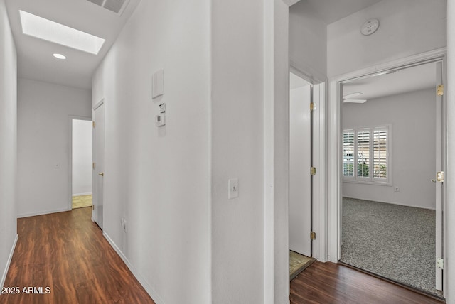 hall featuring recessed lighting, visible vents, wood finished floors, and a skylight