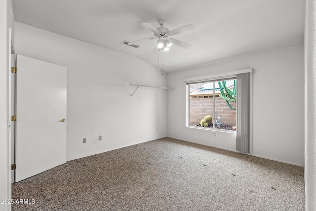 carpeted spare room featuring lofted ceiling, a ceiling fan, and visible vents