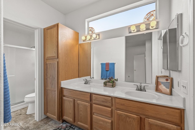 bathroom with double vanity, a shower stall, and a sink