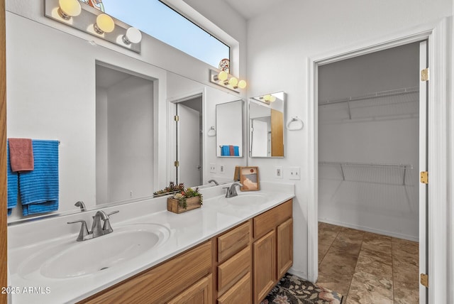 bathroom featuring a sink, a walk in closet, and double vanity