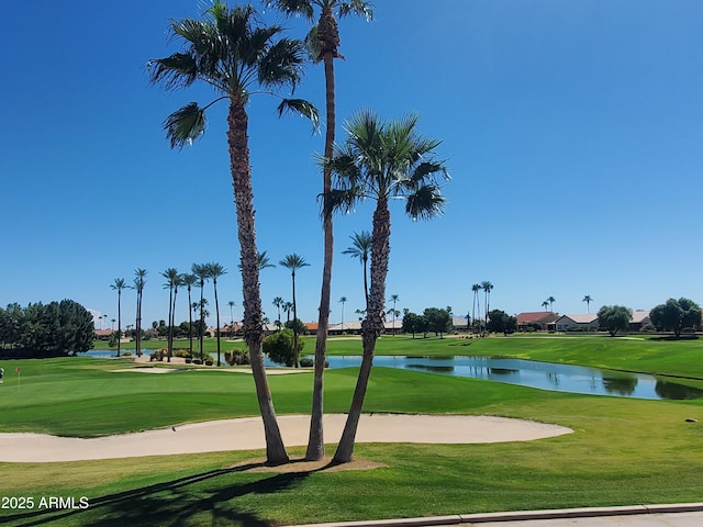 surrounding community with a water view, a lawn, and golf course view