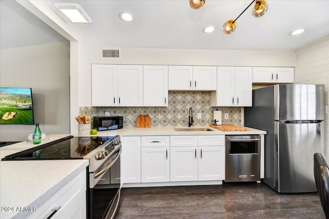 kitchen featuring dark hardwood / wood-style flooring, stainless steel appliances, sink, decorative backsplash, and white cabinets