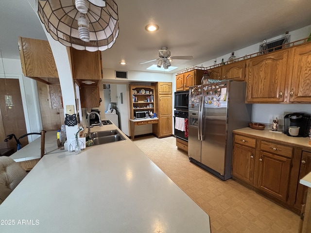 kitchen with oven, a sink, light countertops, stainless steel fridge with ice dispenser, and light floors