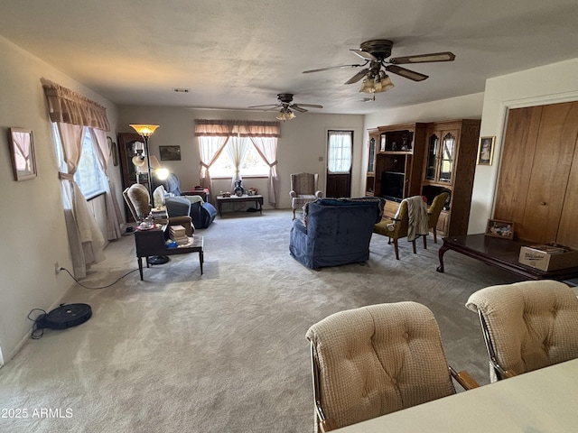 carpeted living area featuring ceiling fan