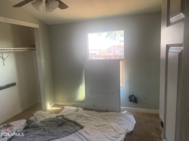 carpeted bedroom featuring ceiling fan, a closet, and vaulted ceiling