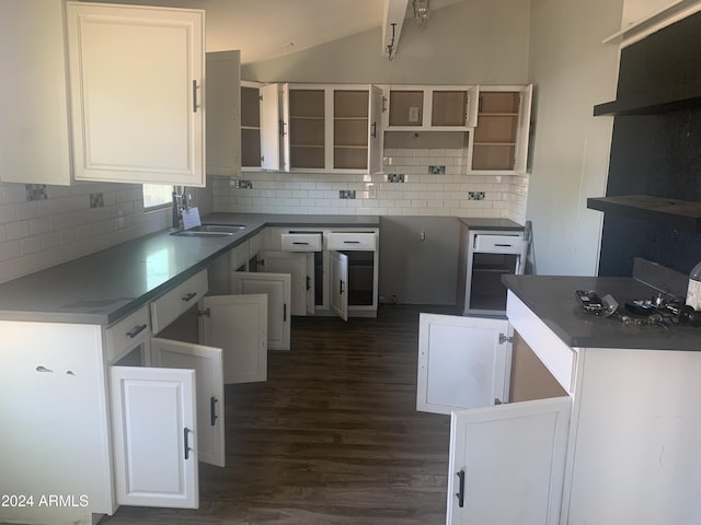 kitchen featuring sink, tasteful backsplash, dark hardwood / wood-style floors, vaulted ceiling, and white cabinets