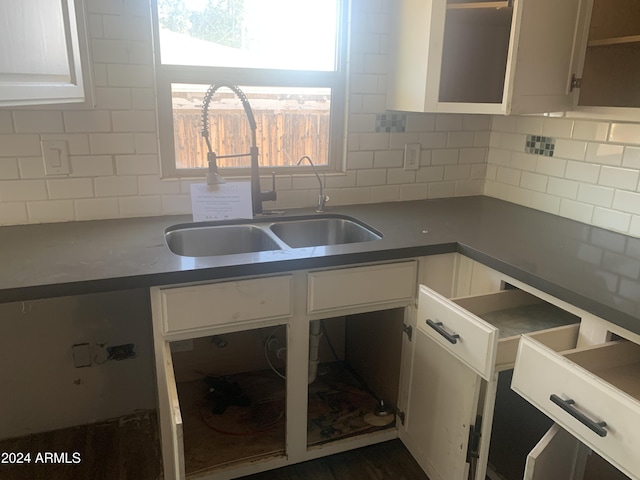 kitchen featuring white cabinets, sink, and tasteful backsplash