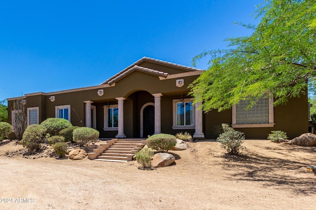 view of front of house featuring stucco siding and a tile roof