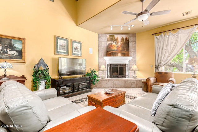 living room featuring a tile fireplace and ceiling fan