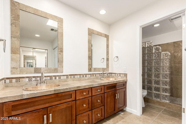 full bathroom with double vanity, a sink, tile patterned flooring, and toilet