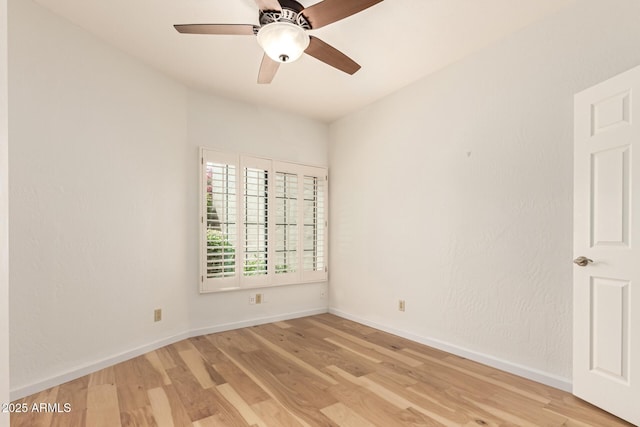 empty room featuring light wood-style floors, a ceiling fan, and baseboards