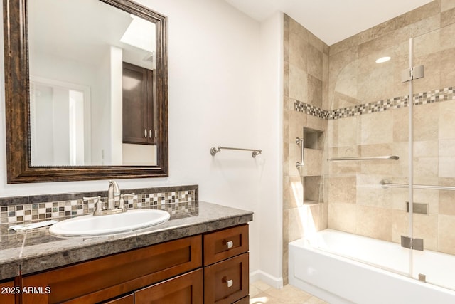 full bath with baseboards, combined bath / shower with glass door, tile patterned floors, and vanity