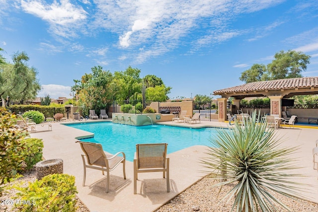 community pool featuring a patio and fence