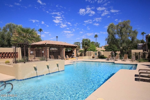 community pool featuring fence and a patio