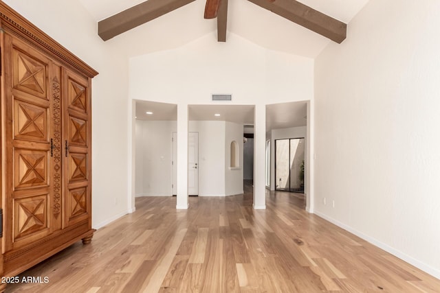 interior space with visible vents, beam ceiling, ceiling fan, high vaulted ceiling, and light wood finished floors