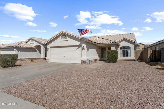 view of front of house featuring a tiled roof, an attached garage, driveway, and stucco siding