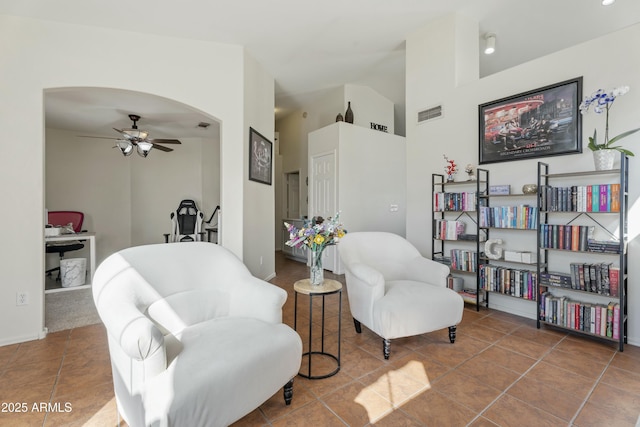 sitting room with arched walkways, visible vents, tile patterned floors, and lofted ceiling