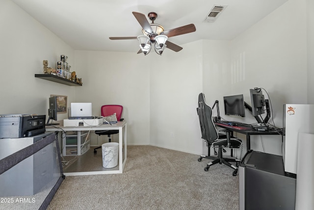 office area with carpet flooring, a ceiling fan, visible vents, and baseboards