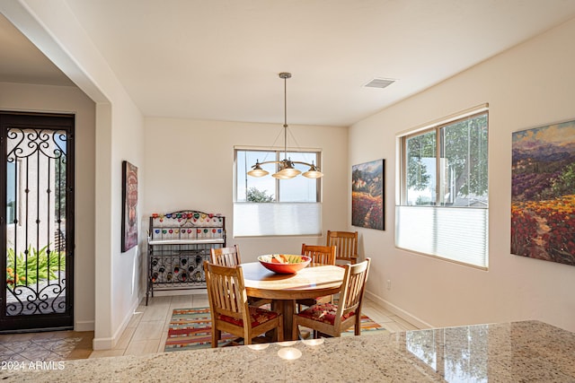 dining space featuring light tile patterned flooring and an inviting chandelier