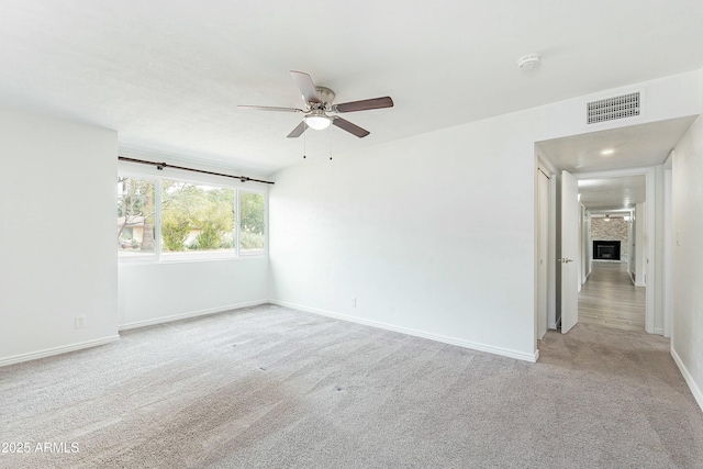 3743 E Coronado Rd, Phoenix, AZ 85008 - carpeted empty room with ceiling fan, baseboards, a glass covered fireplace, and visible vents