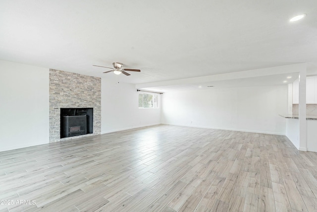 3743 E Coronado Rd, Phoenix, AZ 85008 - unfurnished living room with ceiling fan, a stone fireplace, recessed lighting, light wood finished floors, and baseboards